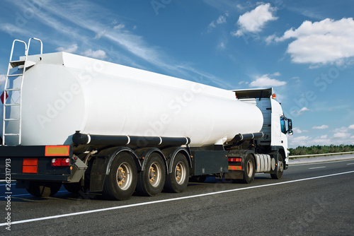 The white oil truck is going up the road. Cargo transportation concept.