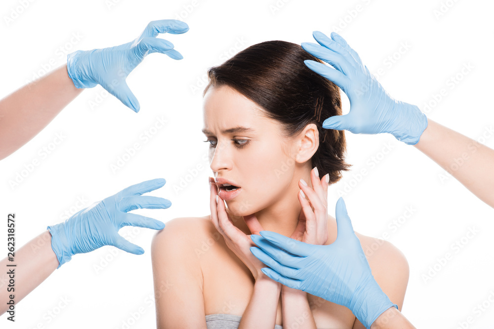 cropped view of plastic surgeons in blue latex gloves near face of shocked girl isolated on white cropped view of plastic surgeons in blue latex gloves near face of shocked girl isolated on white