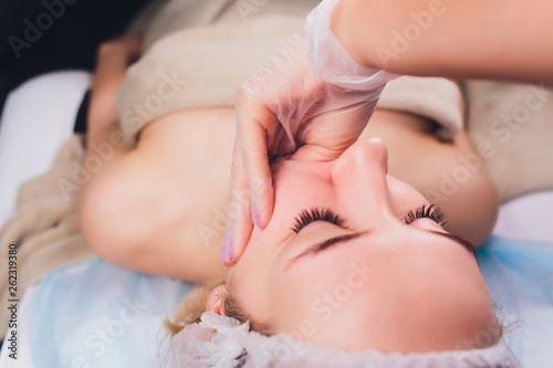 cosmetologist makes a buccal massage of the patient's facial muscles.