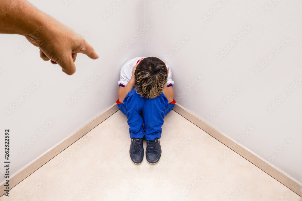 Boy alone being accused by an adult hand. Concept of scolding or punishment. Image about fear and child abuse.
