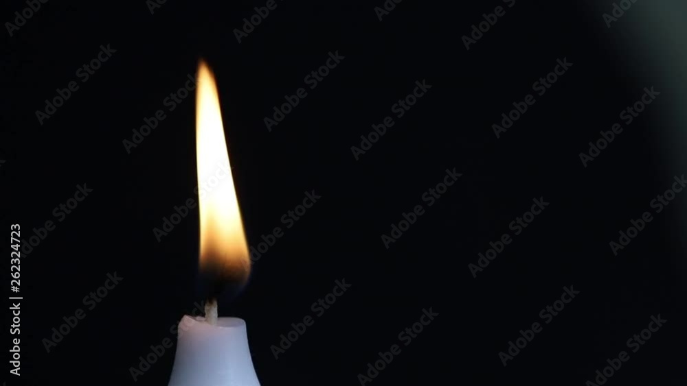 burning candle on a black background burning candle on a black background