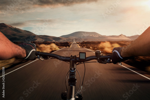Riding a bicycle on an empty highway through the volcanic landscape with copy space photo
