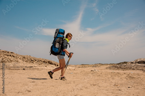 Wallpaper Mural Young female hiker walking with sticks in desert Torontodigital.ca