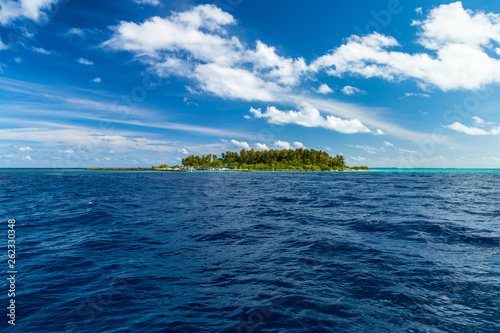 view from boat on sea ocean of tropical paradise maldives island resort with coral reef and turquoise blue ocean tourism blue sky background