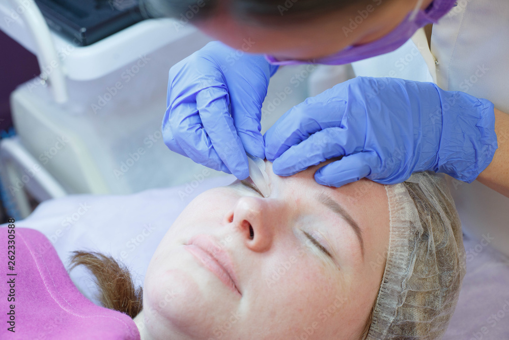 Woman on the procedure for eyelash extensions, eyelashes lamination