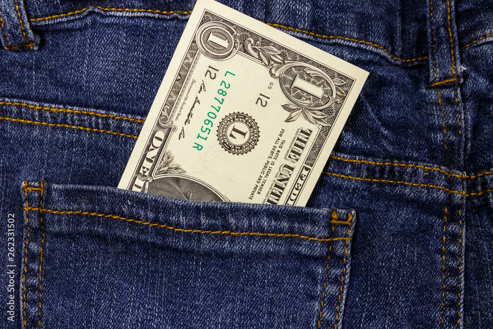 One dollar bill in a pocket of blue jeans One dollar bill in a pocket of blue jeans