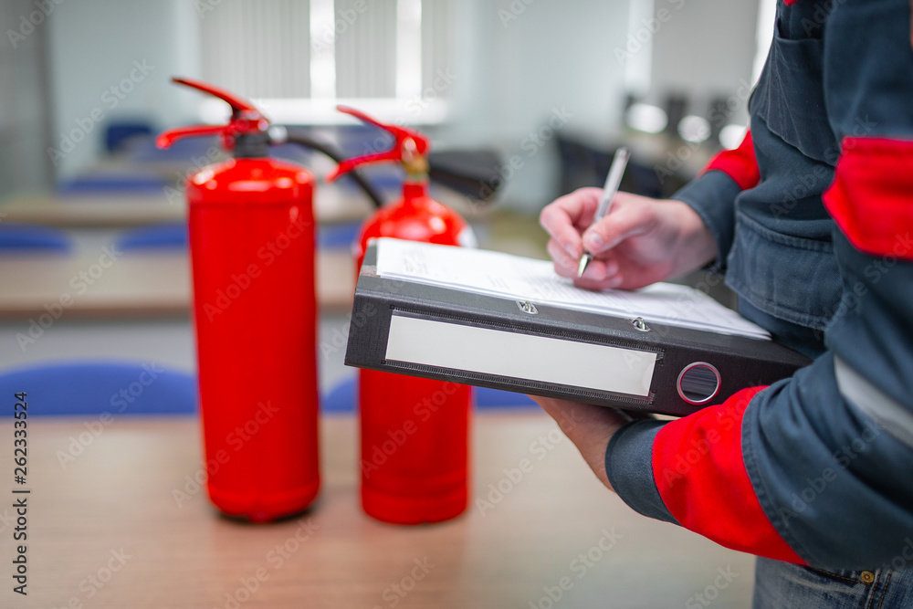Engineer Professional are Checking A Fire Extinguisher Using Clipboard or checking Industrial fire control system,Fire Alarm controller, Fire notifier, Anti fire.System ready In the event of a fire. - obrazy, fototapety, plakaty 