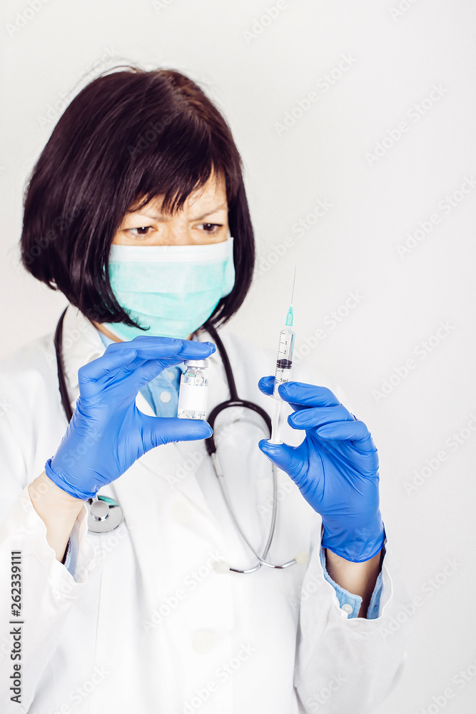 Doctor in white lab coat holding medical ampoule and syringe Doctor in white lab coat holding medical ampoule and syringe