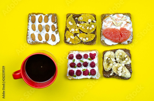 Healthy breakfast toasts with peanut butter, banana, chocolate, chia seeds, raspberries, almond, yogurt, oranges, grapefruit. Color background