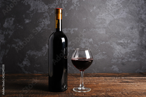 Red wine bottle on a wooden background