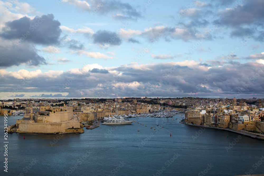 Valletta panoramic view, town fortress walls and ships in the sunset lights. Malta island. 