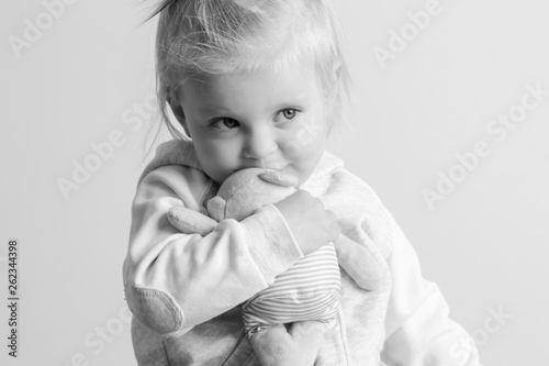 An adorable baby girl hugging with her favorite soft toy