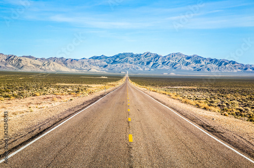 Wide open road and distant mountains in wide open Nevada desert along the Extraterrestrial Highway. photo