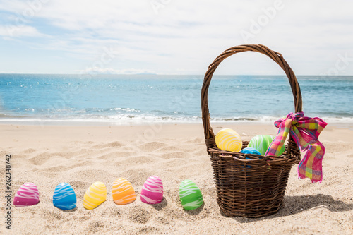 Beach Happy Easter background with basket and color eggs