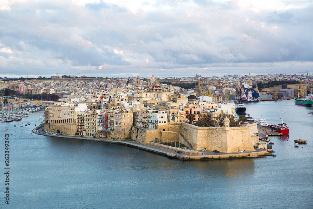 Valletta panoramic view, beautiful colors of sunset. City fortress walls and Mediterranean sea. 