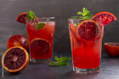 Blood orange cocktail with slices of citrus fruits and mint