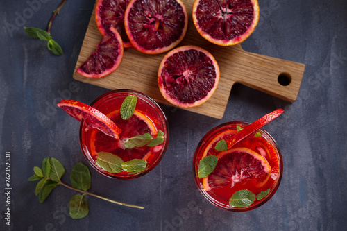 Blood orange cocktail with slices of citrus fruits and mint. View from above, top
