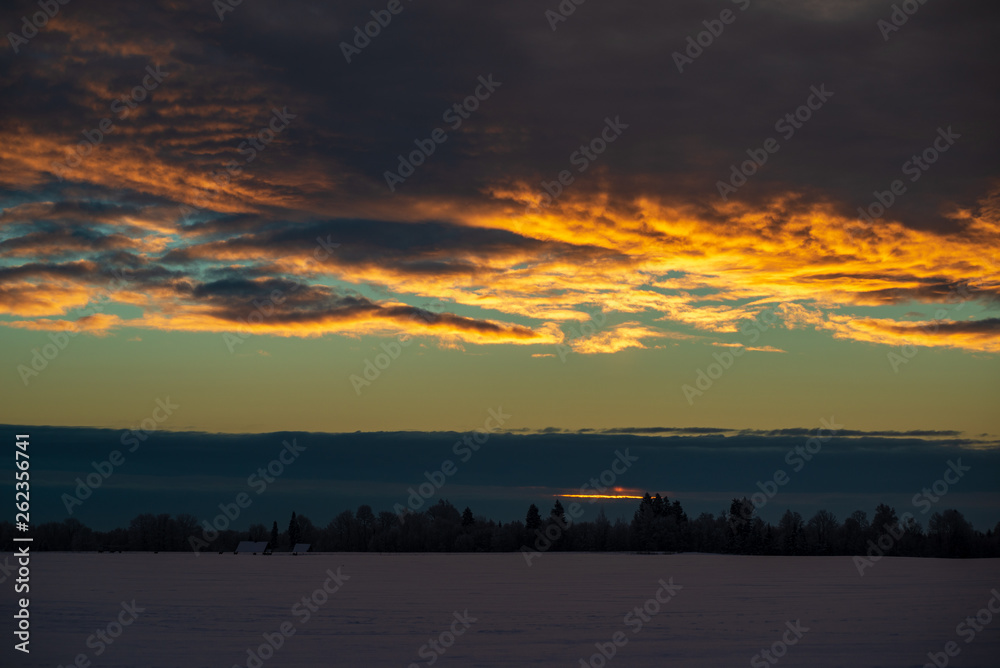 Fototapeta premium colorful sunset light over fields of snow in winter