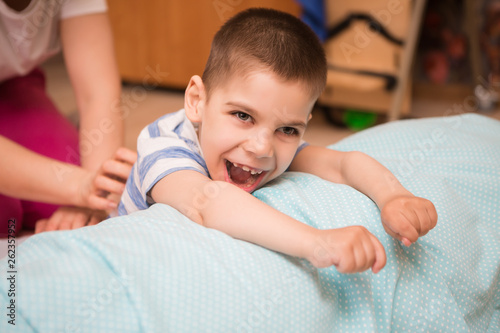 Foto little kid with cerebral palsy has musculoskeletal therapy by doing exercises in body fixing