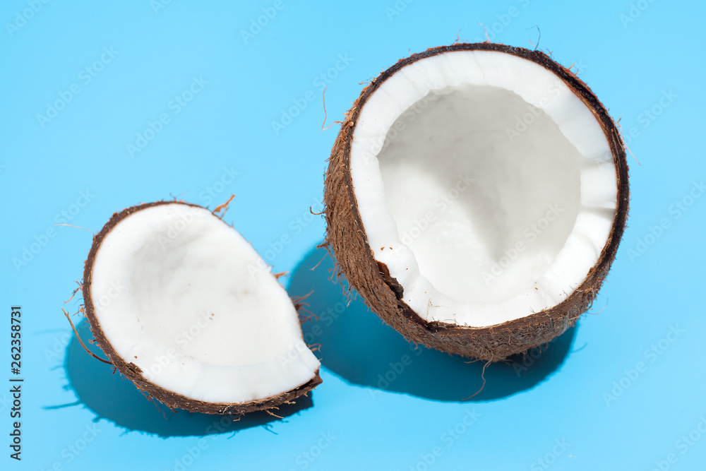 Fresh juicy coconut isolated on a blue background. Concept of Healthy eating and dieting. Travel and holiday concept Fresh juicy coconut isolated on a blue background. Concept of Healthy eating and dieting. Travel and holiday concept