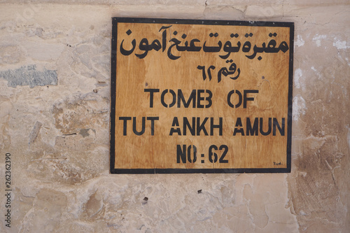 Luxor, Egypt: A plain wooden sign in Arabic and English indicates Tomb KV62, the burial place of pharaoh Tutankhamun, at the Valley of the Kings. photo