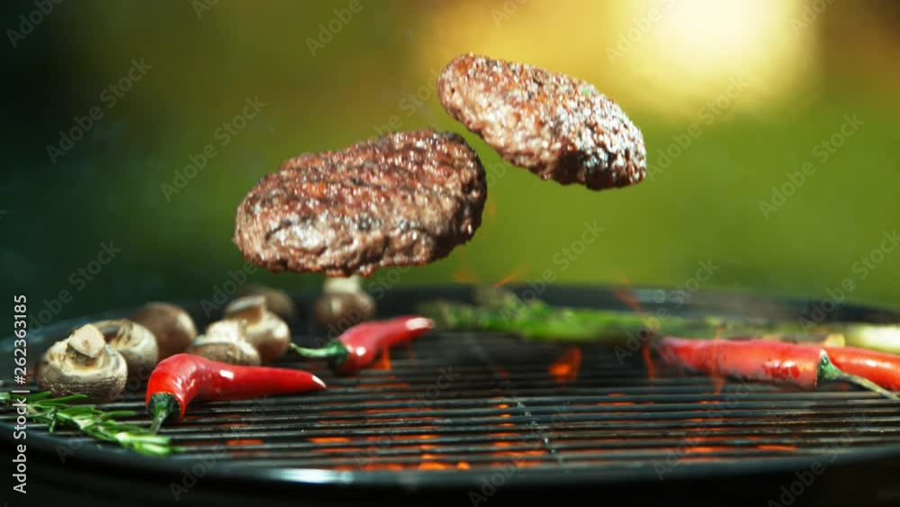 Super slow motion of falling hamburger steaks on grill. Filmed on high speed cinema camera, 1000 fps.