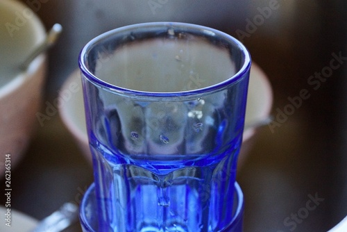 empty blue glass cup with water drops