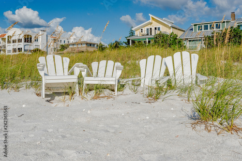 White Adirondack beach chairs on the white sand  on Pass-A-Grille's beach, St. Pete Beach, Florida