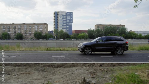 Daylight scenery of urban district with plenty of new high buildings and cute modern black car suddenly stopping on narrow asphalt road. photo