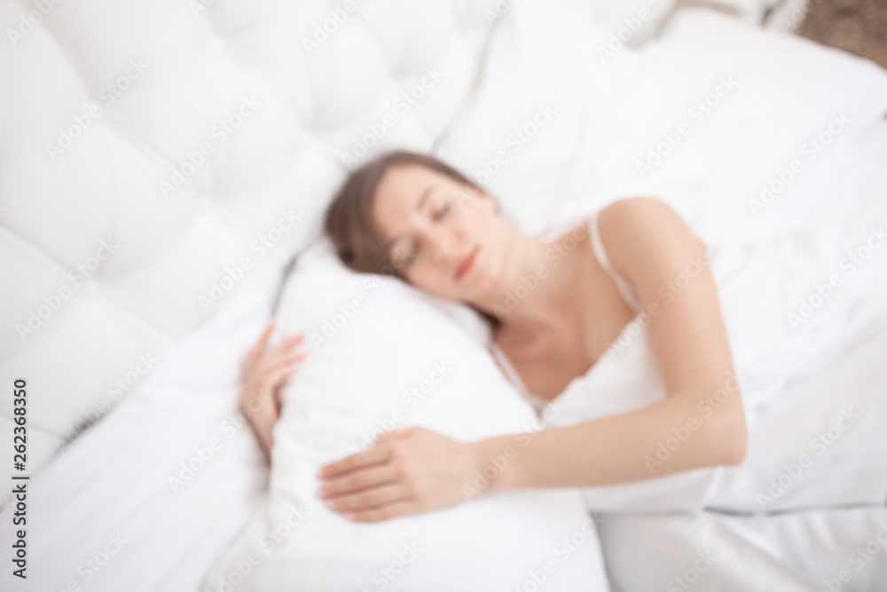 View from above a young pretty woman sleeping. Early morning. Sweet dream. Rest and lazy. Relax on a day off. Blur. Unfocused. Concept. View from above a young pretty woman sleeping. Early morning. Sweet dream. Rest and lazy. Relax on a day off. Blur. Unfocused. Concept.