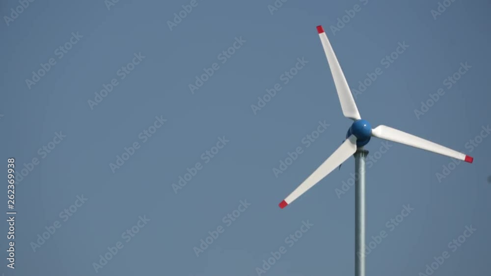 A white pinwheel is spinning under the blue sky. Alternative energy source by wind is important power generation method for human in the future. A white pinwheel is spinning under the blue sky. Alternative energy source by wind is important power generation method for human in the future.