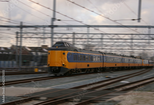 yellow train or intercity driving very quick with motion blur, scenic wallpaper