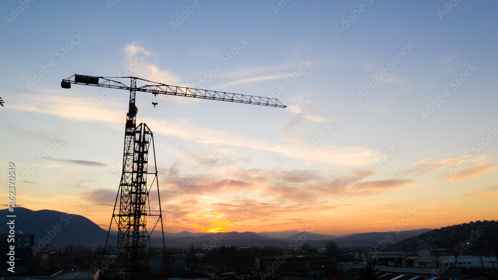 Drone shot of a Construction site on the Sunset. Tower crane