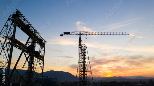 Drone shot of a Construction site on the Sunset. Tower crane