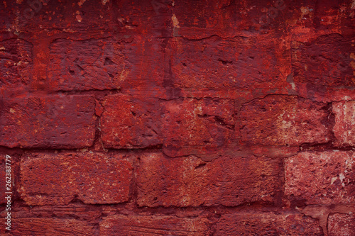 Old grungy brick wall. Free space for an inscription. Can be used as a background or poster. Fragment of a wall with bumps and peeling paint.