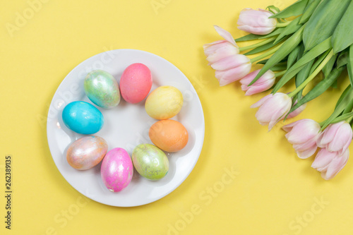 Bright and colorful Easter background with dyed eggs and fresh tulips