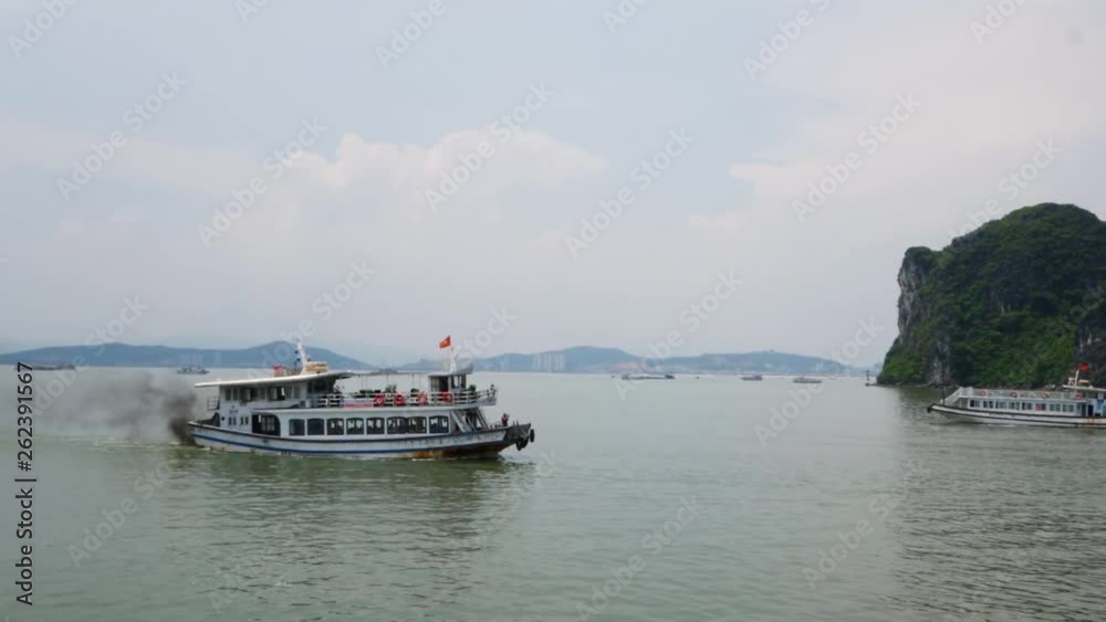 Passenger boat with dark fumes traveling along Halong Bay in Vietnam Passenger boat with dark fumes traveling along Halong Bay in Vietnam