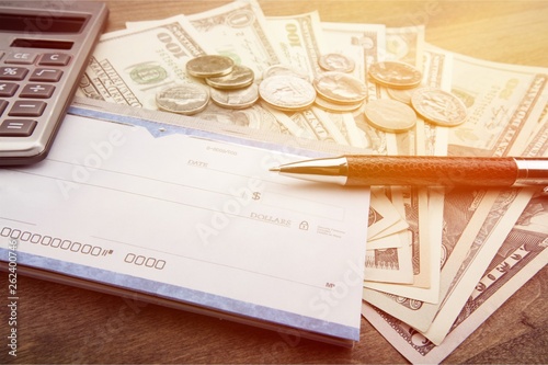 Money and checkbook with pen, calculator on table photo
