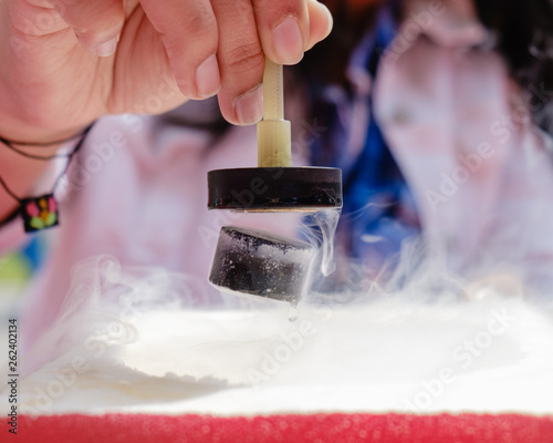 Demonstration of Quantum Magnetic Levitation and Suspension Effect. A splash of liquid nitrogen cools a ceramic superconductor forcing it to float in air below a magnet