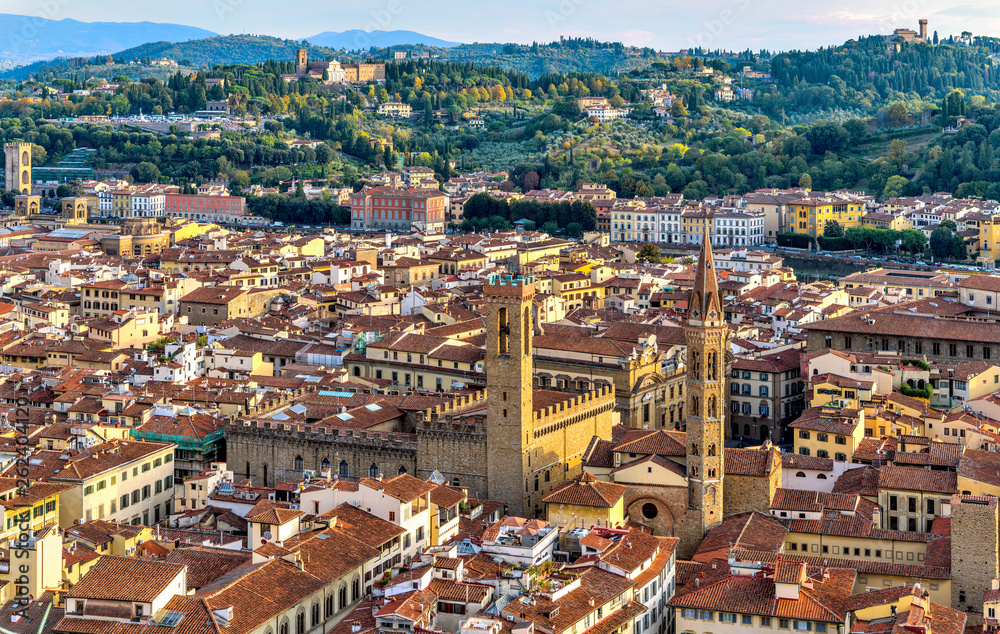 Sunset Florence - A panoramic Autumn sunset view of Bell tower of Badia Fiorentina church, right, and Volognana tower of Bargello palace, left, in south side of historical Old Town of Florence, Italy.