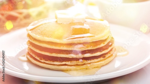 Stack of Small pancakes in syrup on background