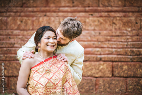 Asian bride and Caucasian groom have romantic time with Thailand dress photo