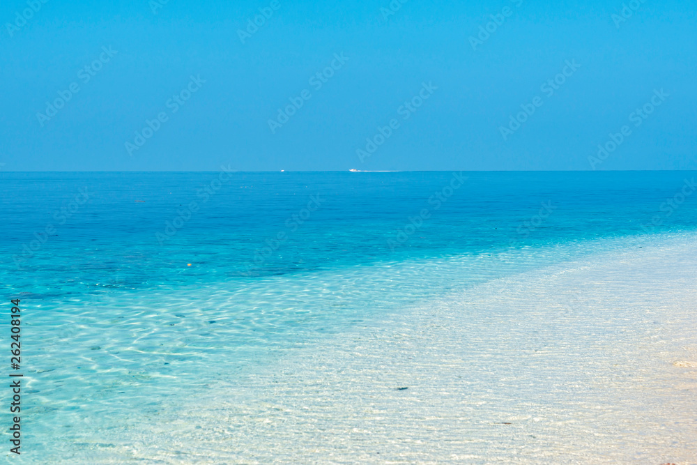 View on the blue ocean from a white sand beach