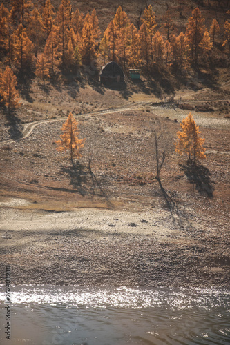 Mongolian yurt and ruined house near the large mountain and river. Autumn landscape. Altai mountains. photo