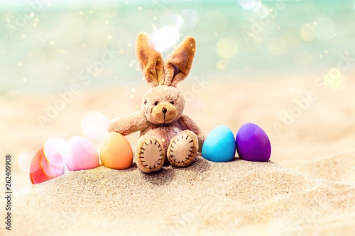 Easter bunny and color eggs on beach sand