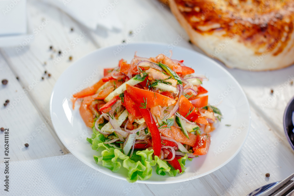 Vegetable salad on the white plate. Achik Chukchuk salad with tomatoes and onion. Vegetable salad on the white plate. Achik Chukchuk salad with tomatoes and onion.