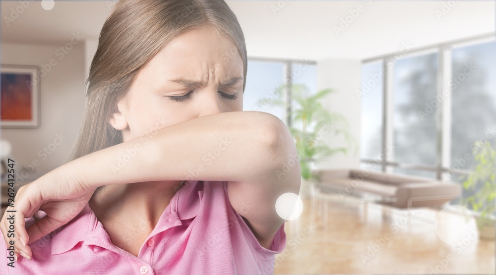 Young woman scratching her nose with elbow on dark gray background Young woman scratching her nose with elbow on dark gray background