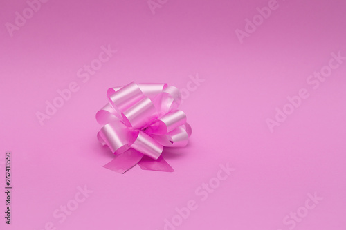 Big round bow in pink color isolated on pink background close up. Bow image for decoration design.