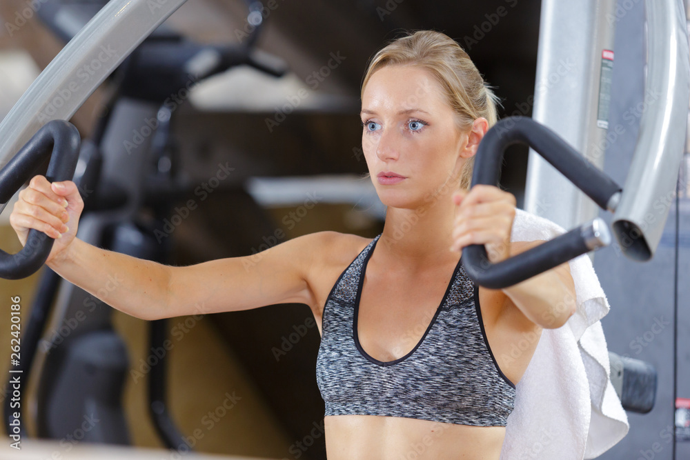 Obraz premium woman doing arm exercises in the gym