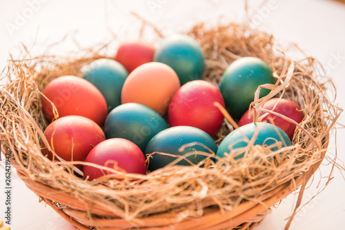 easter colorful eggs in a basket spring concept on a white background with room for text